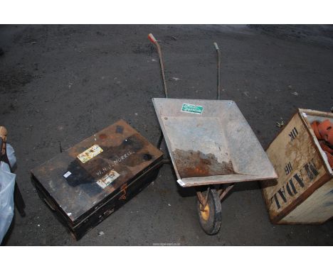A galvanised wheel barrow on solid tyres plus a metal trunk.