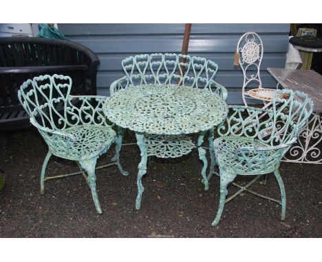 A metal patio table, 31" diameter x 27" high with two chairs and a bench, finished in mint green. 