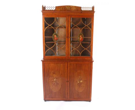 An Edwardian satinwood display cabinet, the base enclosed by a pair of panel doors painted with oval panels of musical instru
