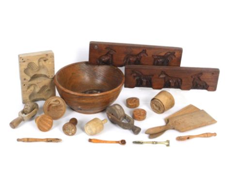 A group of kitchen treen comprising an elm bowl, 22cm dia, together with a collection of butter and other moulds, rollers, a 