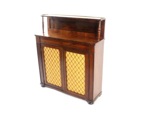 A Regency rosewood chiffonier, enclosed by a pair of brass grille doors with pleated linings, below a panel back surmounted b