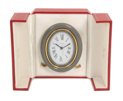 A modern alarm clock – Cartier, Paris, oval frame on easel strut, engraved “Cartier Paris” and stamped “Swiss Made 7509/30306