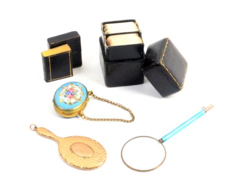 Five pieces comprising an enamel handled magnifying glass, 10cm, a 9ct gold miniature hand mirror, 7.2cm, a gilt metal frame 
