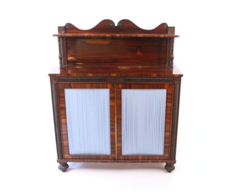 A Regency rosewood chiffonier, enclosed by a pair of doors with pleated silk linings, flanked by split ring turned pilasters,