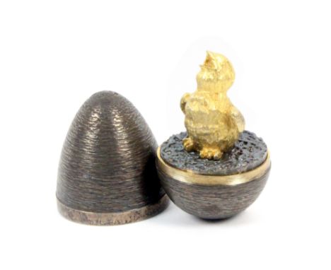 A Stuart Devlin silver and silver gilt surprise egg, the egg with textured ground, the interior with gilded standing chick, L