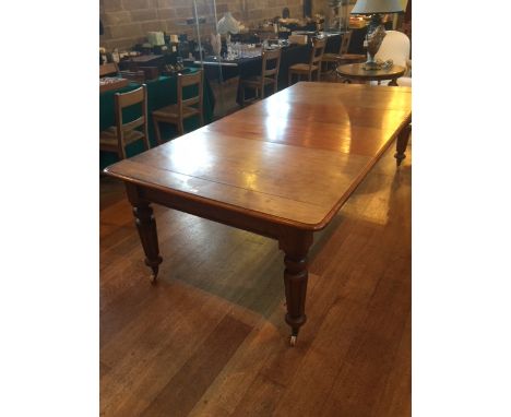 A Victorian mahogany draw leaf extending table, the moulded edge top over a frieze on four turned and tapering legs to brass 