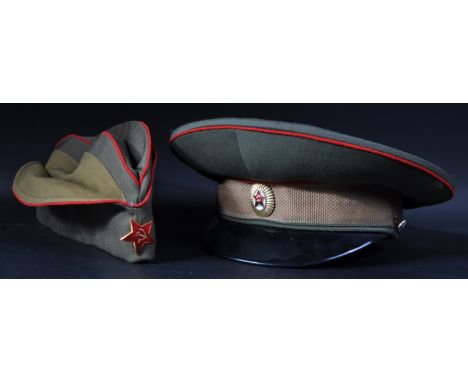 Two vintage USSR Russian Soviet Red Army Military uniform caps comprising a peaked cap and field service cap. Both hats with 