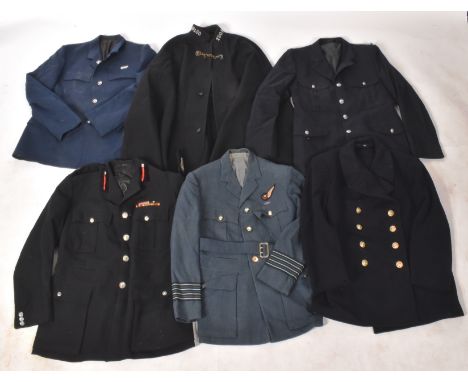 A collection of assorted British Military, Transport and Police uniform items to include; Royal Navy wool overcoat, Police Co