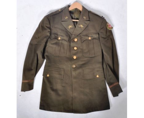 An original 20th Century US United States Army Officers Captain uniform tunic. The dark olive jacket with belted waist having