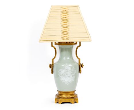 A CELADON GLAZED TABLE LAMP with gilt metal mounts, 24cm wide overall x 52cm high to the top of the fitting 