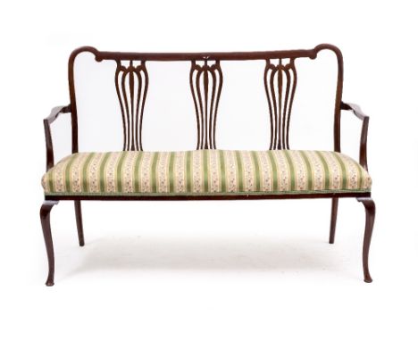 AN EDWARDIAN MAHOGANY CHAIR BACKED SOFA with pierced splats, open arms, overstuffed upholstered seat and standing on delicate