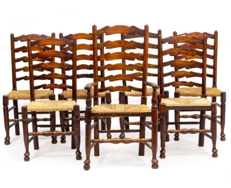A SET OF SEVEN LADDER BACK DINING CHAIRS with woven rush seats (one carver and six standards)