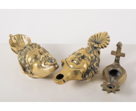 Small brass oil lamp, designed with a mask, 18cm, one similar, and two other brass hand lamps, (4).