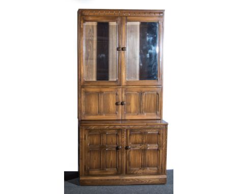An Ercol blonde beech book cabinet with glazed doors, 98 x 50 x 197cms.