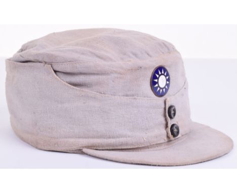 WW2 Chinese Nationalists Army Field Cap, of grey cloth with two button front. Enamel circular badge fitted to the centre of t