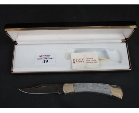 An American Buck Knives model 110 Damascus bladed steel and horn handled lock bladed clip point clasp knife.  Original fitted