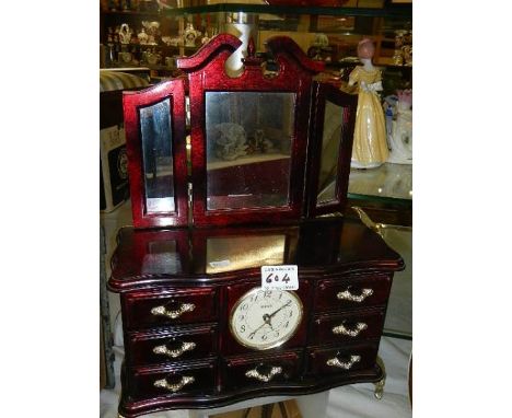 A jewellery box with clock containing an assortment of costume jewellery.