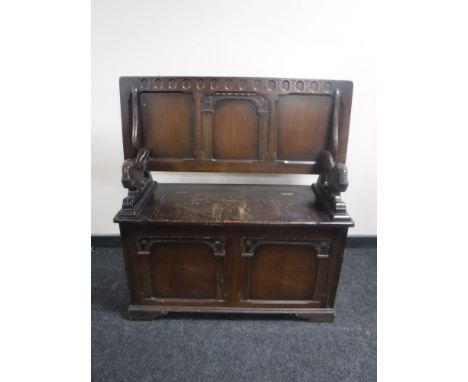 A carved oak storage monk's bench 