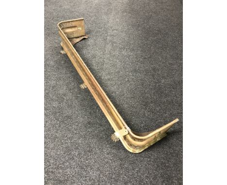 An early 20th century brass fender on paw feet 