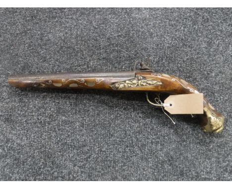 A replica flintlock pistol with mother of pearl inlay