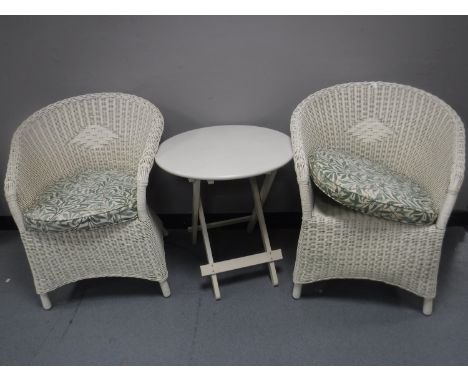 A pair of white loom armchairs and a folding Ikea table 