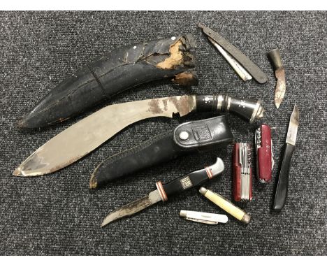 A Kukri knife in sheath together with a hunting knife and a small collection of penknives