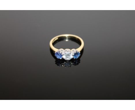 An 18ct gold three stone sapphire and diamond ring, the central stone weighing approximately 0.5 carat, size M CONDITION REPO