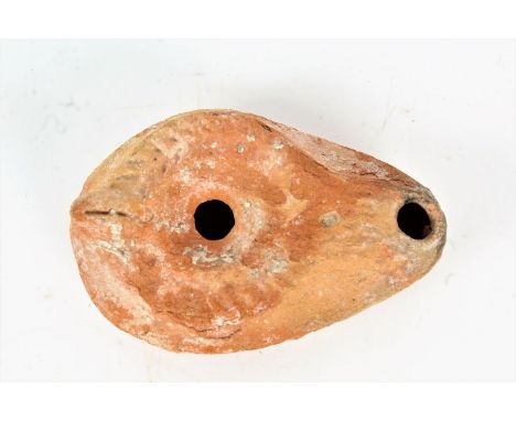 A terracotta oil lamp, in the Roman style with a scallop shell design, 10cm wide&nbsp;