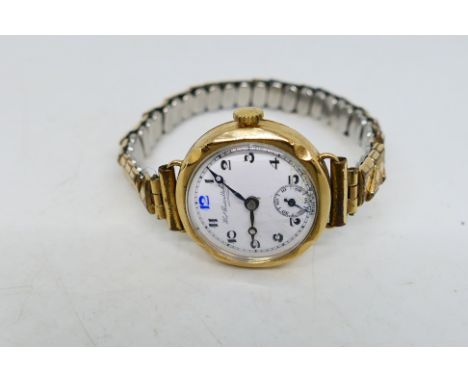 A 9ct gold cased wrist watch, the signed white enamel dial with Arabic numerals and subsidiary seconds dial. [W]