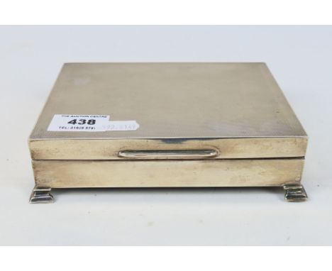 A silver cigarette box with engine turned decoration, raised on bracket feet, Birmingham assay 1957, sponsors mark for Turner
