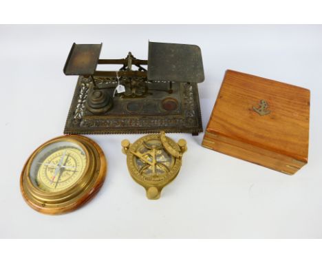 Lot to include a brass nautical sundial compass, contained in case, a wood and brass table compass and a set of postage type 