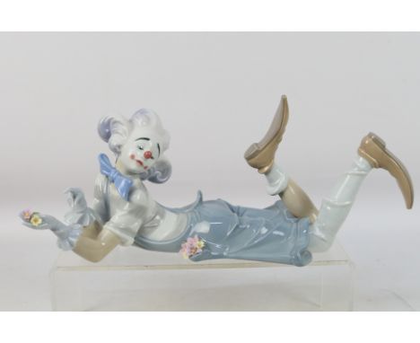 Lladro - A large figure depicting a recumbent clown with flowers, # 6913, The Magic Of Comedy, approximately 34 cm (l). [W]Co