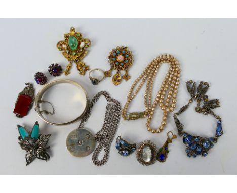 A collection of vintage costume jewellery to include a silver hinged bangle and silver pendant and chain, brooches, earrings 