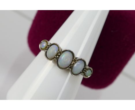 A five stone opal ring, stamped 18ct PLAT, size N+½, 3.2 grams. [W]