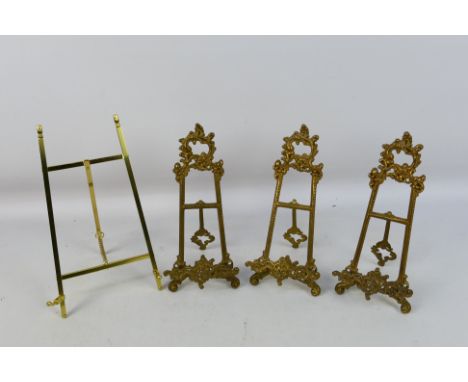 Three cast brass, easel plate stands and one similar. [W]Condition Report: Pieces appear in good condition, no significant is