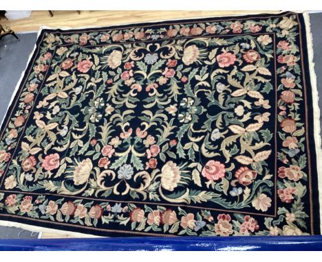 A black ground floral needlework tapestry panel 340cms x 260cms
