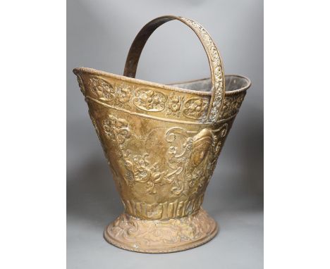 An embossed brass helmet coal bucket, 48cms high