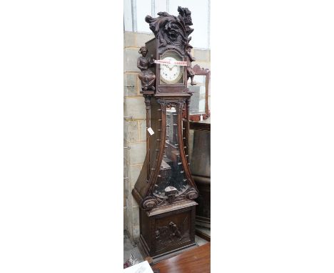 An early 20th century Flemish carved oak and walnut longcase clock, height 240cms.