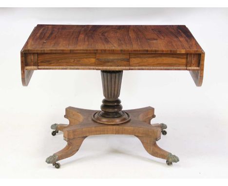 A late Regency rosewood pedestal sofa table, having twin blind frieze drawers and raised on a quatraform platform on square c