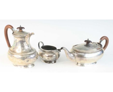 A George V silver three-piece tea set, comprising teapot, coffee pot and cream jug, each piece of plain oval squat baluster f