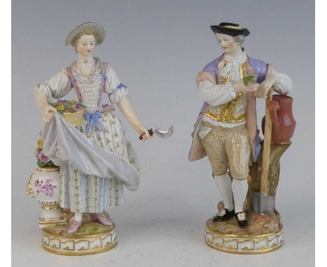 A pair of Meissen porcelain figures of gardeners, late 19th century, each shown in 18th century dress, underglaze blue crosse