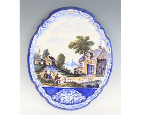 A massive Dutch Delft polychrome pictorial wall plaque, Royal Tichelaar Makkum, circa 1900, decorated with figures before a c