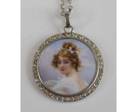An early 20th century white metal, enamel and diamond pendant, the central ground finely enamel decorated with a head and sho