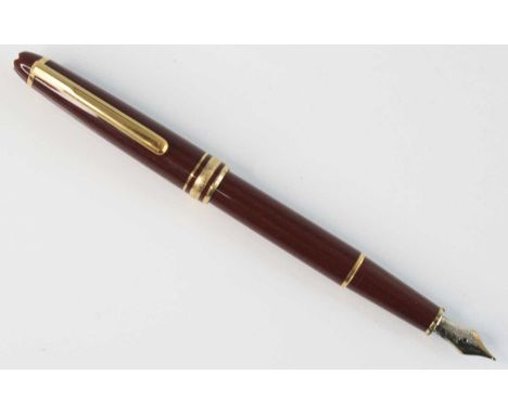 A Montblanc Meisterstück fountain pen, burgundy resin with gold-coated trim, the cap with white star emblem to tip of cap and