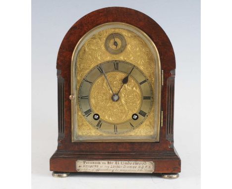 A Gillett &amp; Johnston burr walnut cased bracket clock of small proportions, having a domed top and fluted canted corners, 