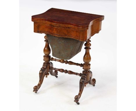 A Victorian figured walnut combination games and needlework table, of serpentine outline, the fold-over top opening to reveal