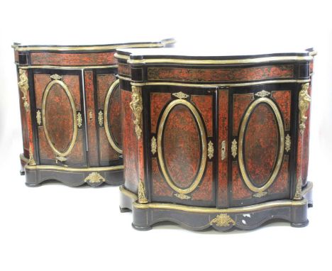 A pair of mid-Victorian ebonised and boulle side cabinets, each of serpentine outline with black marble tops, brass mounts, r