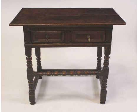 A Jacobean period oak single drawer side table, having a two-plank top, geometric moulded long frieze drawer, and raised on b