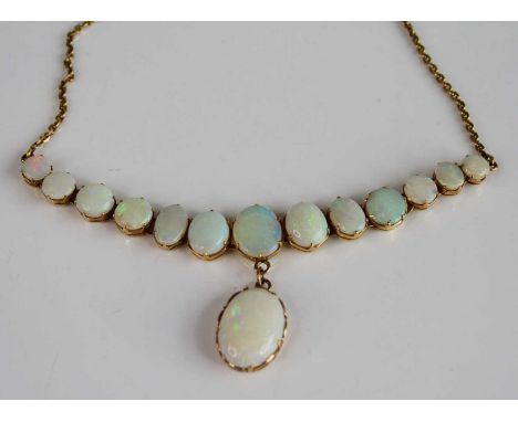 A yellow metal opal necklace, featuring 13 graduated opal cabochons with an opal pendant suspended from the centre, attached 