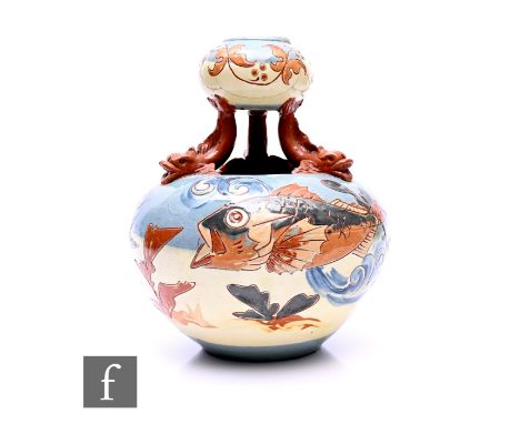 C H Brannam - A Barum art pottery two tier vase, of compressed ovoid form moulded dolphin supports and incised slip glazed fi